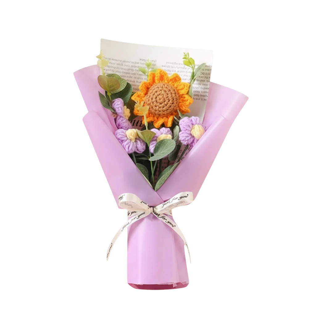 MieleGifts handcrafted crochet flower bouquet with a sunflower and purple daisies wrapped in pink paper and ribbon.