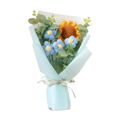 MieleGifts handcrafted crochet bouquet with a yellow sunflower, blue daisies, and eucalyptus leaves in light blue wrap.